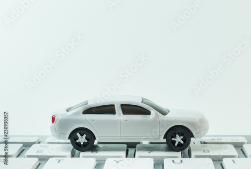 The white toy car on keyboard computer close up image background.