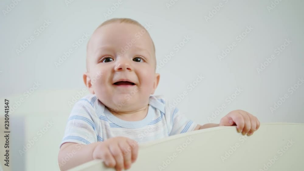 Cute baby playing in her crib at home. Close-up shot Cute baby playing in her crib at home. Close-up shot