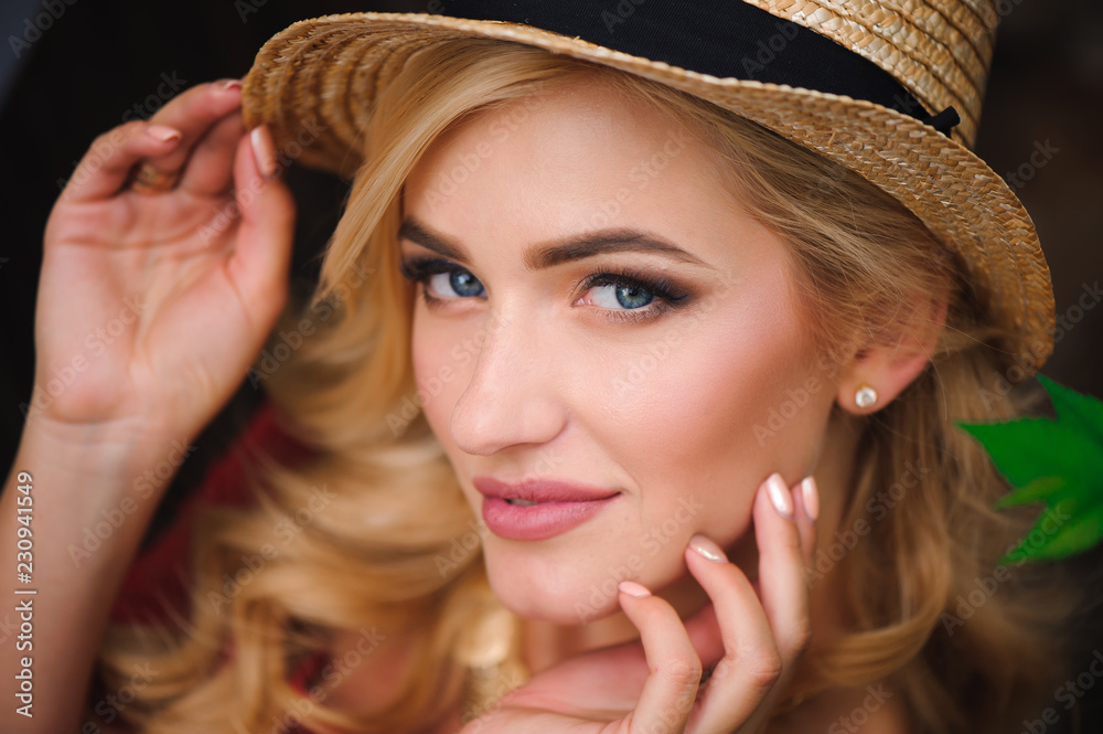 Portrait of a beautiful girl with blond hair. Stylish girl is sitting on a park bench. Fashion model Portrait of a beautiful girl with blond hair. Stylish girl is sitting on a park bench. Fashion model