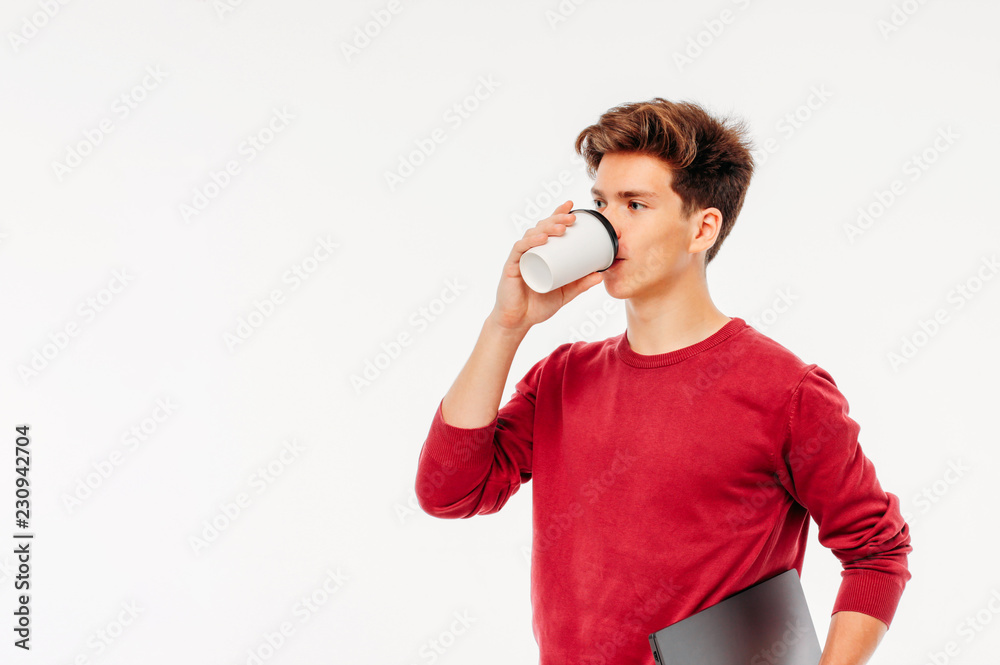 Smiling young man student with coffee to go and laptop on white background Smiling young man student with coffee to go and laptop on white background