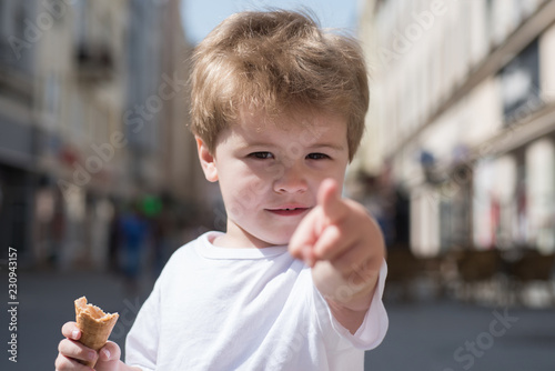 Look over there. Little child point finger on city street. Small boy with stylish haircut. Little child with short blond hair. Healthy hair care habits. Hair care products. Having a modern haircut