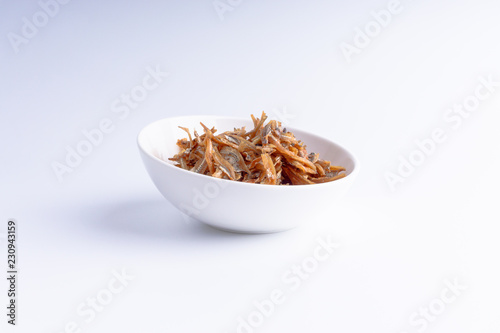 Fried anchovies on white background with selective focus and crop fragment