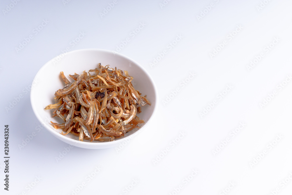 Fried anchovies on white background with selective focus and crop fragment Fried anchovies on white background with selective focus and crop fragment