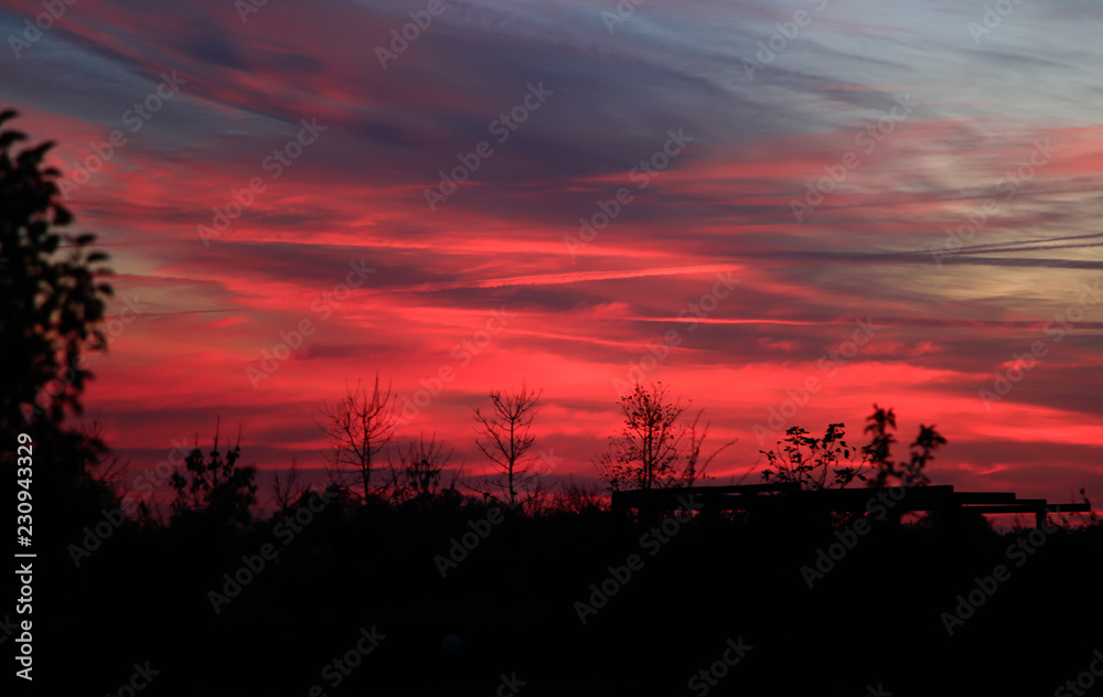 Beautiful sunset. Blurred shot of the dramatic sunset on steppe. Red clouds as a defocused natural background.