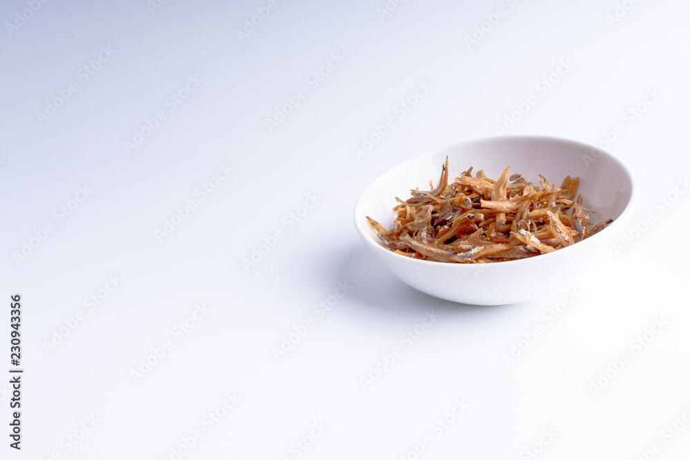 Fried anchovies on white background with selective focus and crop fragment Fried anchovies on white background with selective focus and crop fragment