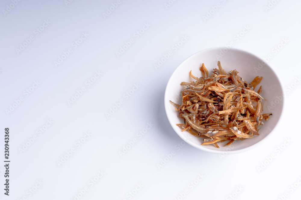Fried anchovies on white background with selective focus and crop fragment Fried anchovies on white background with selective focus and crop fragment