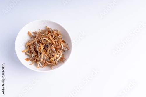 Fried anchovies on white background with selective focus and crop fragment
