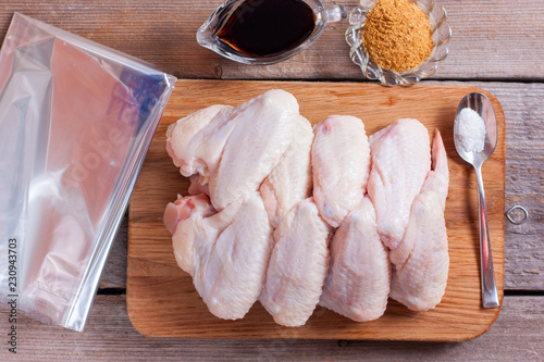 Fotografie Step-by-step cooking of chicken wings with spices and soy sauce in a baking bag,