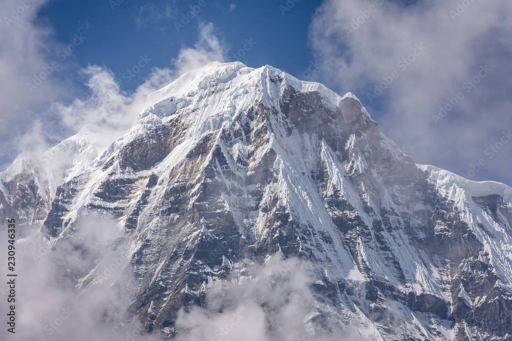 Annapurna South Summit surrounded by rising clouds in  Himalayas