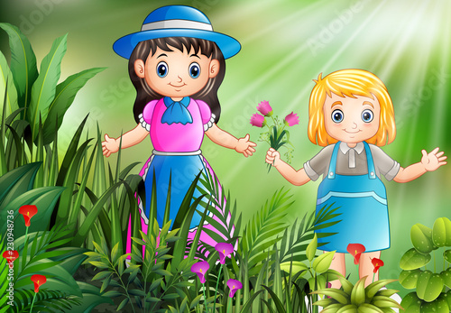 Happy little girls picking a flowers in the garden