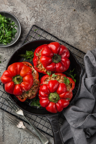 red bell peppers stuffed with meat, rice and vegetables on cast iron pan