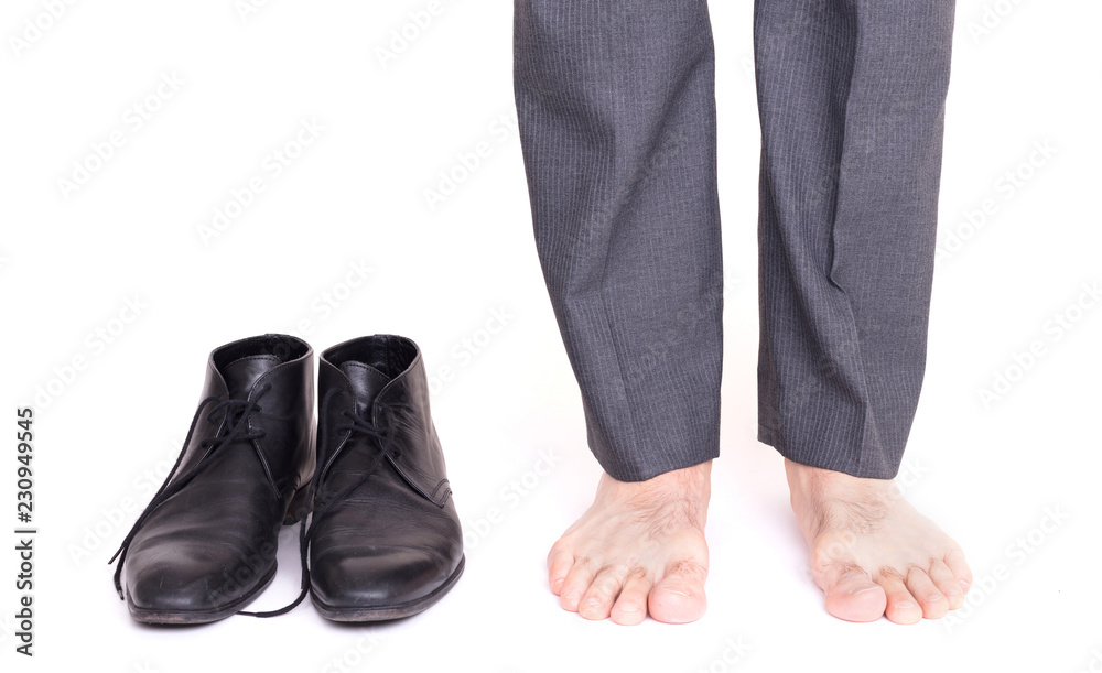 Businessman standing next to his shoes