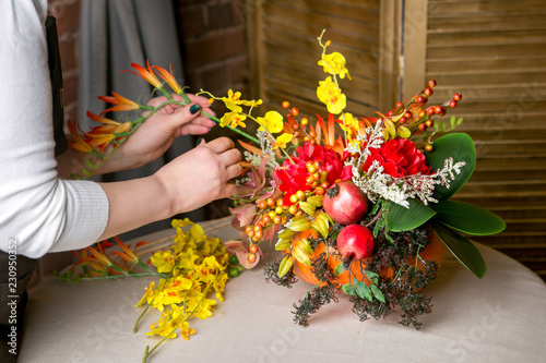 Konstfotografi Florist at work: How to make a Thanksgiving centerpiece with big pumpkin and bouquet of flowers