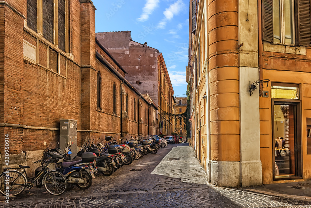Scooters near the basilica wall in the narrow italian street