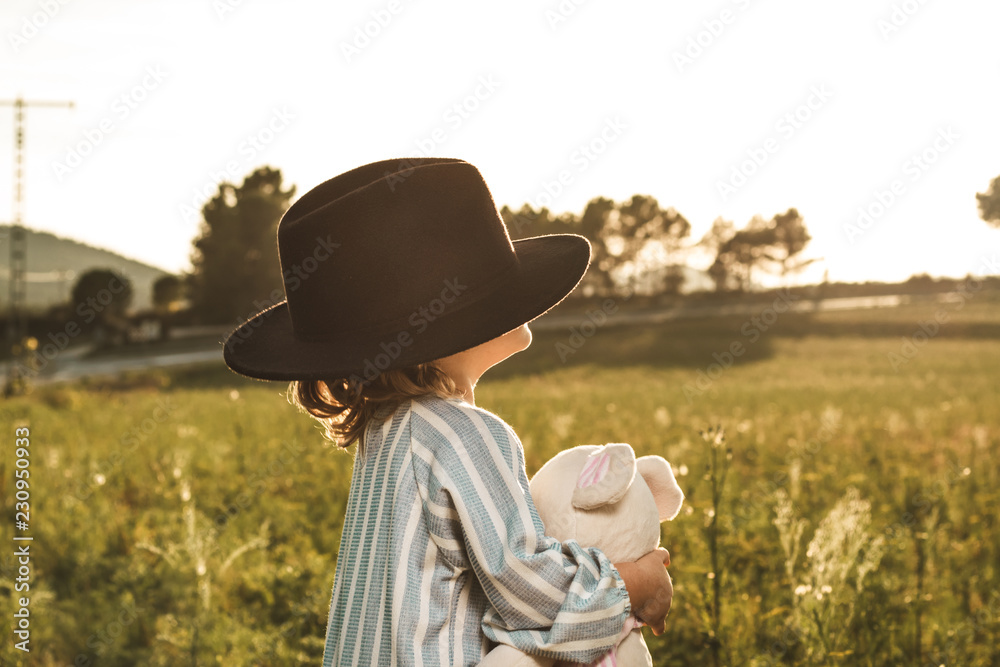 Portrait of a beautiful little girl with a hat. Funny picture of children