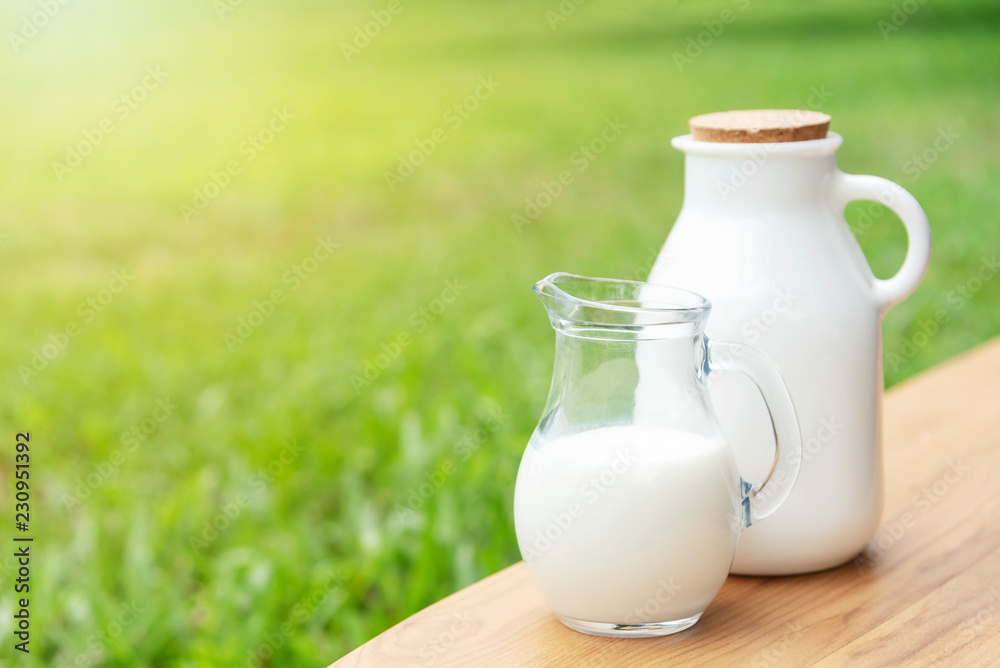 Fresh milk on wood table with green nature background. Fresh milk on wood table with green nature background.