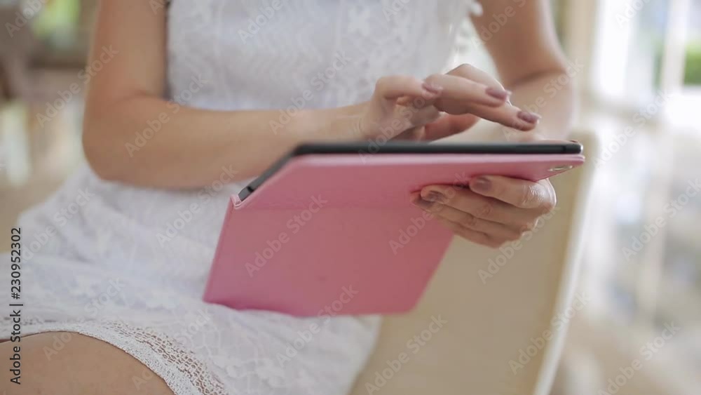 Clouse up attractive woman working on a tablet in the hotel lobby Clouse up attractive woman working on a tablet in the hotel lobby