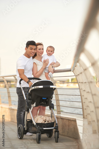 Happy young multi-ethnic family with little child walking outdoors
