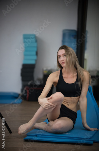 Young blonde girl in yoga class posing. Healthy lifestyle in fitness club. Stretching
