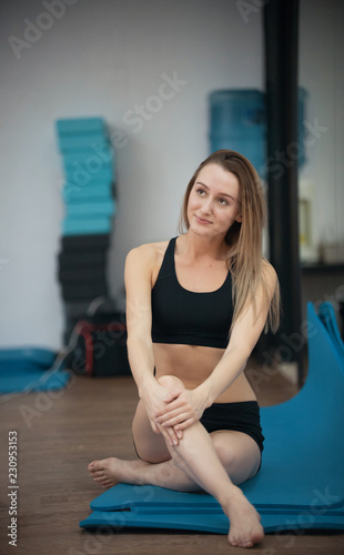 Beautiful young blonde girl in yoga class posing. Healthy lifestyle in fitness club. Stretching