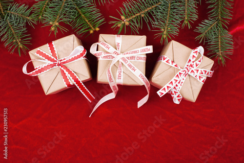 Christmas gifts with red ribbon on red background with decorations. Christmas background with copy space.