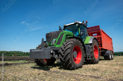 heavy green tractor for plowing the ground in the field