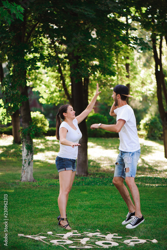 A young couple celebrate victory playing tic-tac-toe in the park