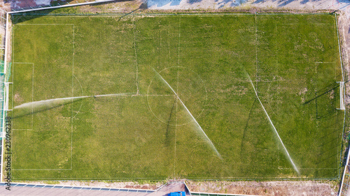 Aerial view of watering the lawn of a football field, top view
