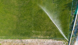 Aerial view of watering the lawn of a football field, top view
