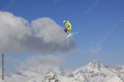 Flying skier on mountains. Extreme winter sport.