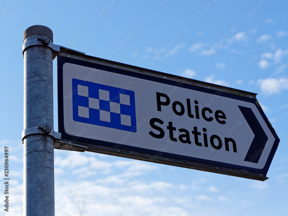 Naklejka premium A signpost indicates the police station in United Kingdom