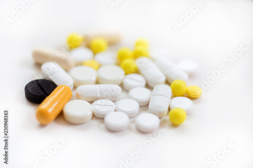 It is a lot of different tablets and drugs are scattered on a white background