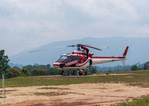 Red Helicopter on Helipad for helicopter landing surrounded with lush green jungles