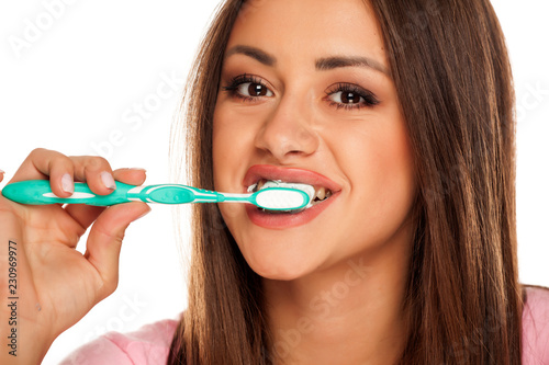 young woman brushing her teeth tooth brush on white background