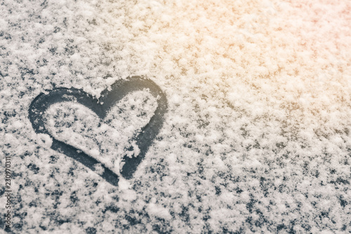 Finger-drawn heart on a snow-covered window