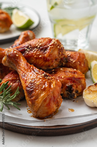 Chicken legs with sauce, rosemary and lime on a white background. Copy space.
