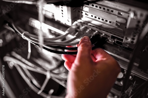 Close-Up of technician plugging patch cable in a rack mounted