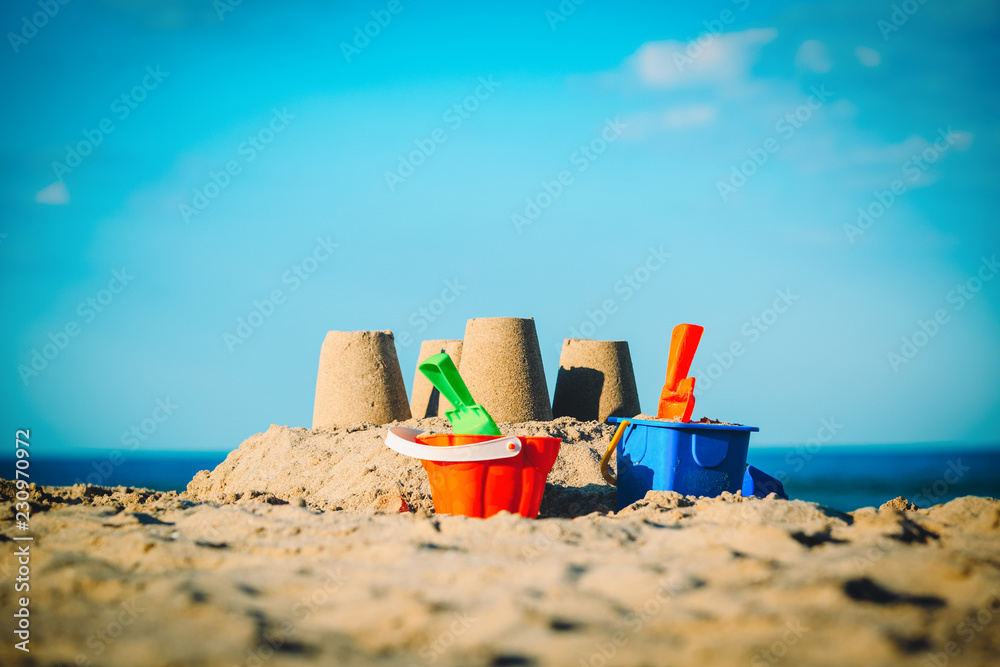 Sand castle on tropical beach and kids toys Sand castle on tropical beach and kids toys