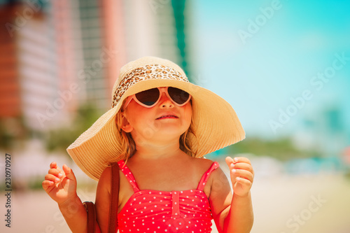 cute little girl with big hat on city beach