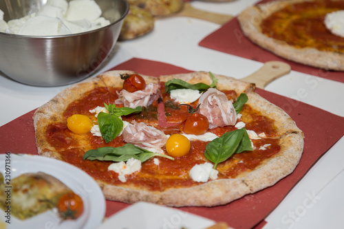 Pizza Maker who Prepares a Delicious Pizza with Bacon and Cherry Tomatoes