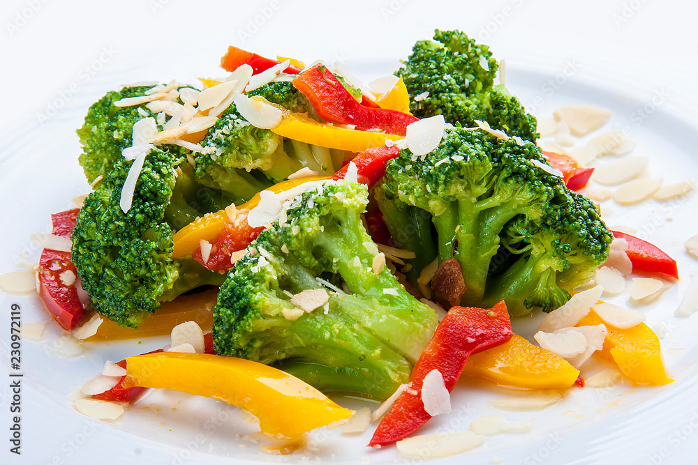 Dietary broccoli with vegetables and peanuts. On a white plate. Dietary broccoli with vegetables and peanuts. On a white plate.