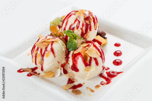 Ice cream balls with fruit on a white plate