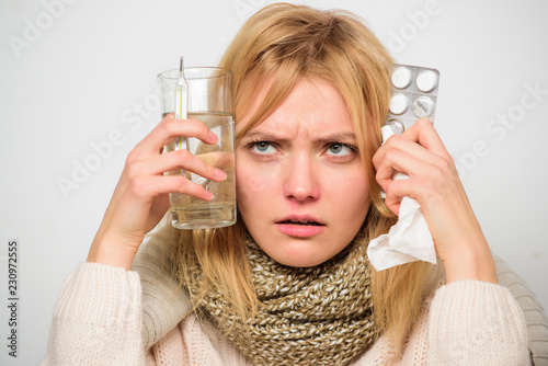 Girl hold glass water tablets and thermometer light background close up. Get rid of flu. Getting fast relief. Ways to feel better fast. Flu home remedies. Woman wear warm scarf because illness or flu