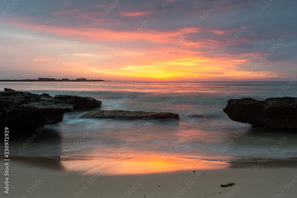 Fototapeta premium Sunrise at Pretty Beach, Australia. Reflections and colour over the ocean.