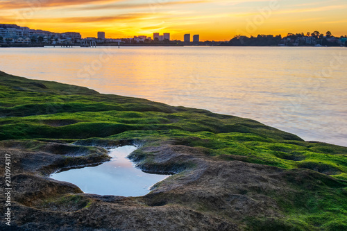 Sunset over the Parramatta River at Cabarita. Mossy rocks at a suburban sunset in Sydney Australia photo