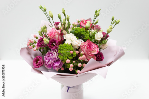 Beautiful bouquet in pink paper on a light background