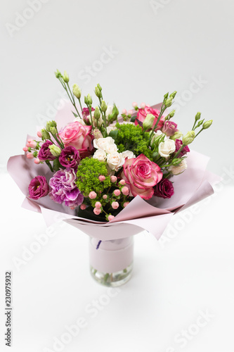 Beautiful bouquet in pink paper on a light background