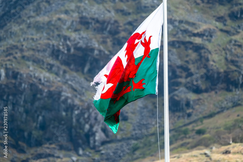 Welsh flag waving in the beautiful landscape of Llanberis, Snowdonia in Wales at the lake padarn