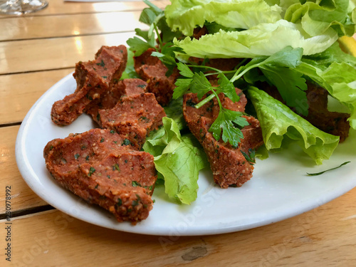 Turkish Food Cig Kofte with lettuce and parsley in plate.