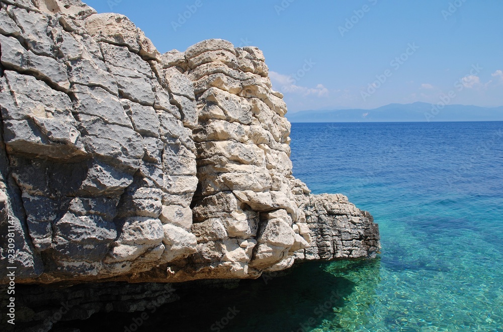 The rocky coastline of Levrechio beach at Loggos on the Greek island of Paxos.